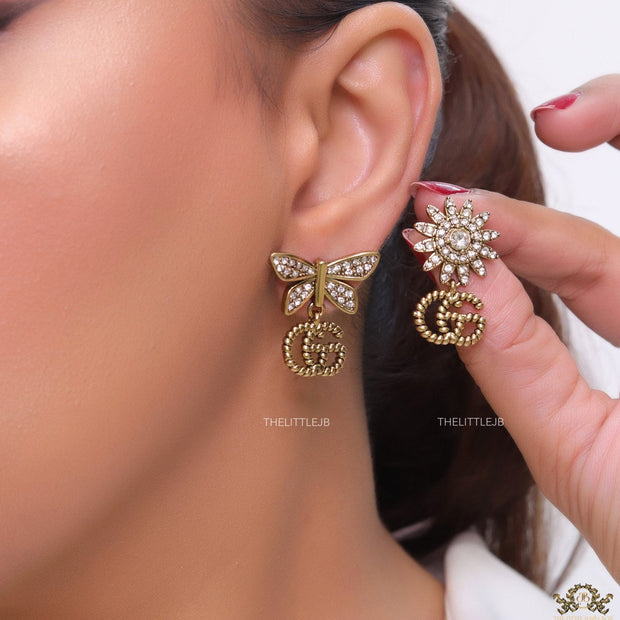 Flower and butterfly cz earrings in antique gold with twin G drops