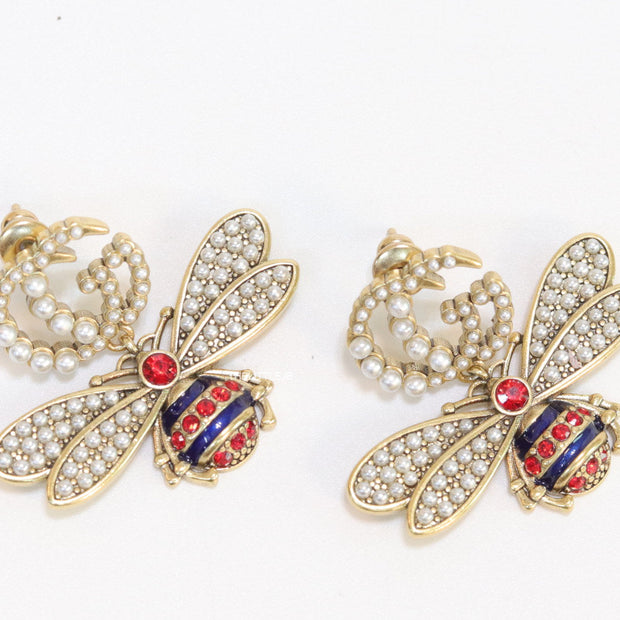 Pearl twin G earrings with pearl and multi cz bees in golden finish