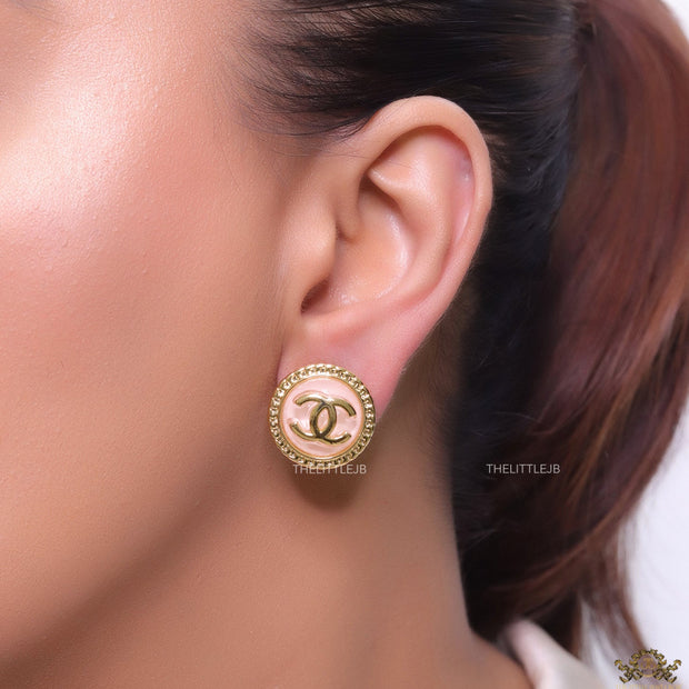 Twin C motif gold plated round studs on pink acrylic base
