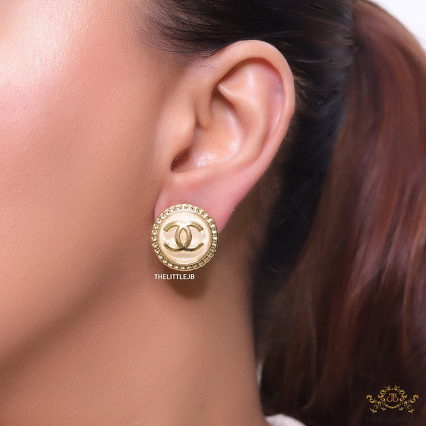 Twin C motif gold plated round studs on pearly cream acrylic base