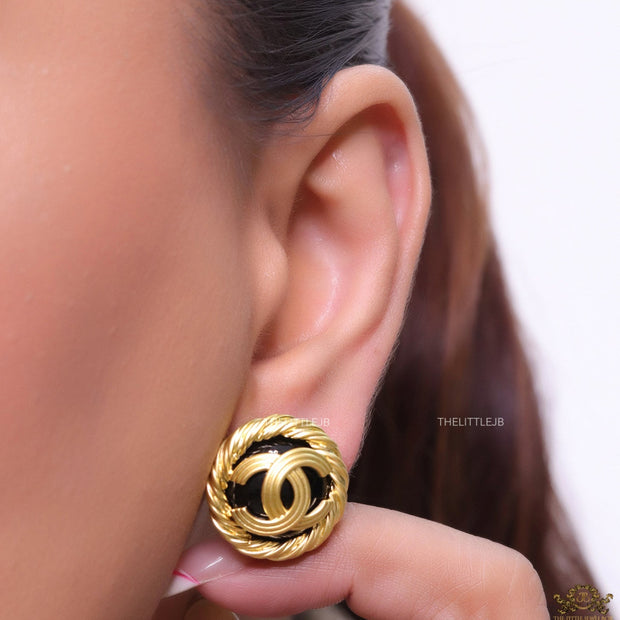 Twin C motif matt gold plated round studs on black base