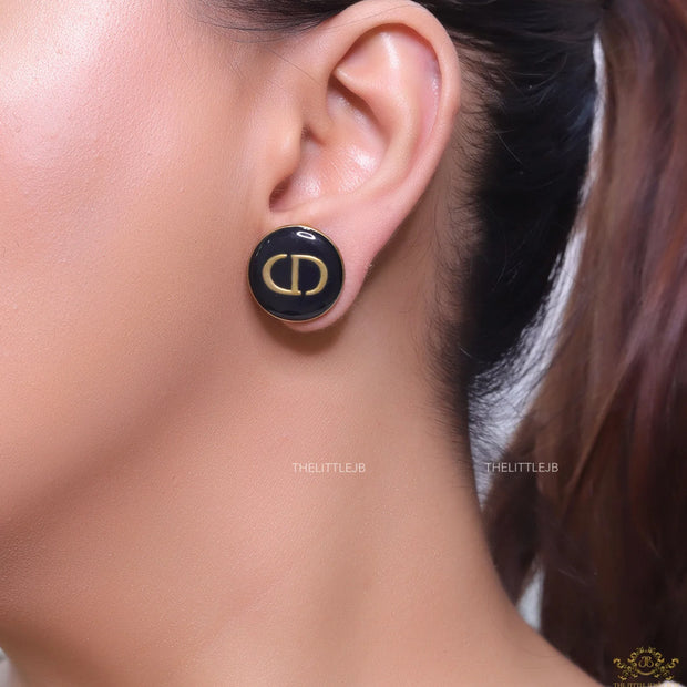 Round black stud earrings with golden alphabets