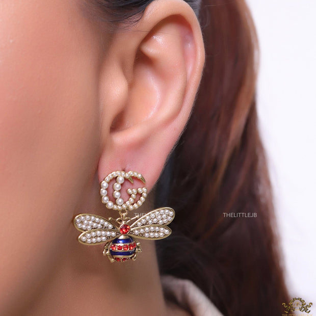 Pearl twin G earrings with pearl and multi cz bees in golden finish