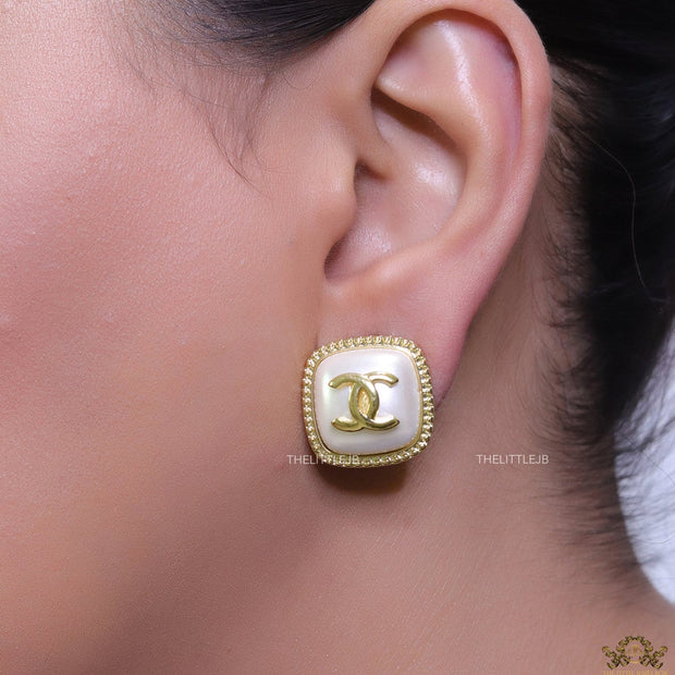 Twin C motif square studs in golden and MOP finish