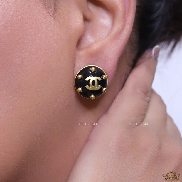 Black and golden twin C motif round stud earrings