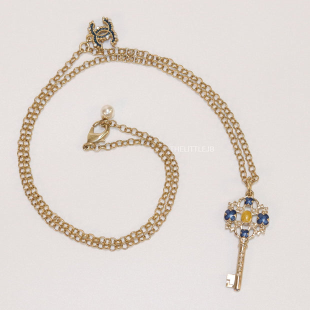 Golden chain necklace with blue clovers studded key pendant