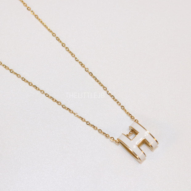 Gold chain necklace with white enamel H motif